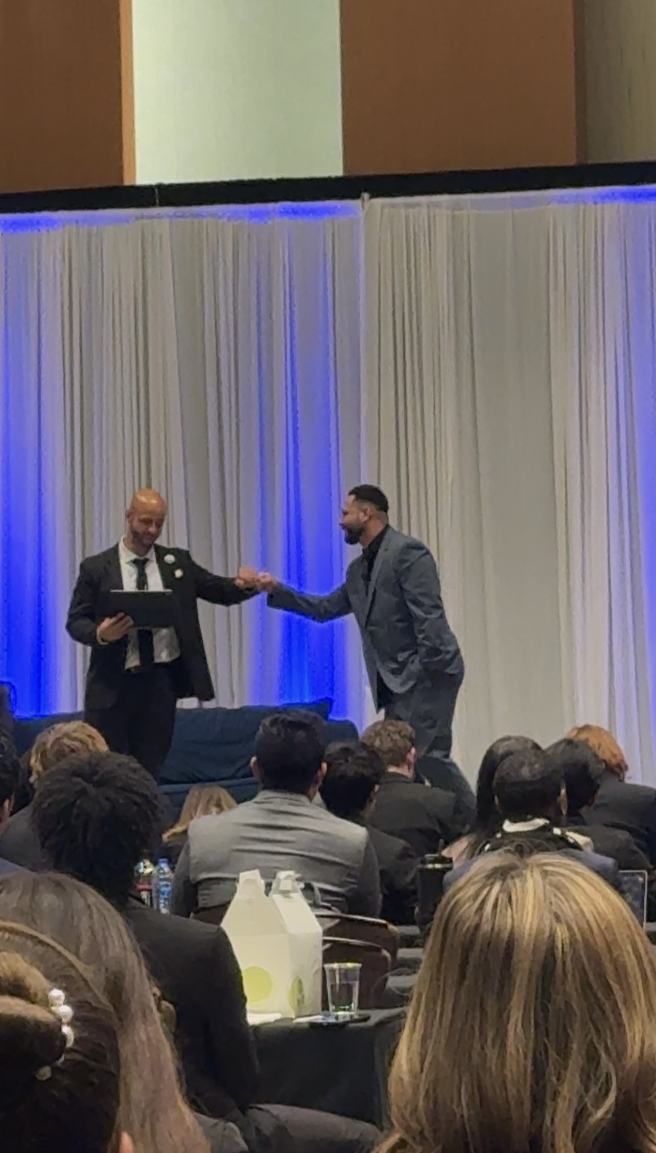 Infinite Reign Solution team member receiving recognition on stage at a professional leadership event